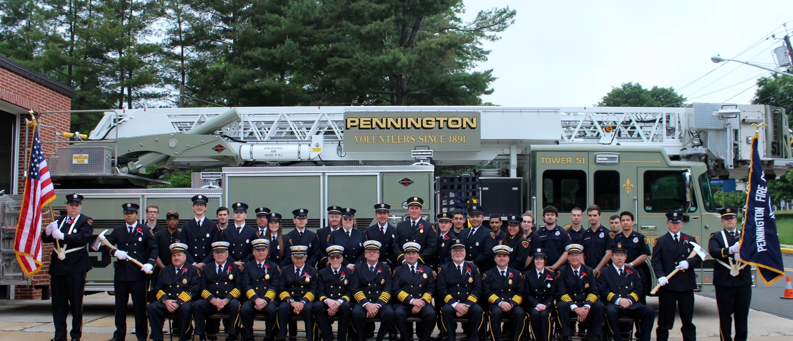 Group photo of the members of the pennington fire company infront of the Tower Truck.
